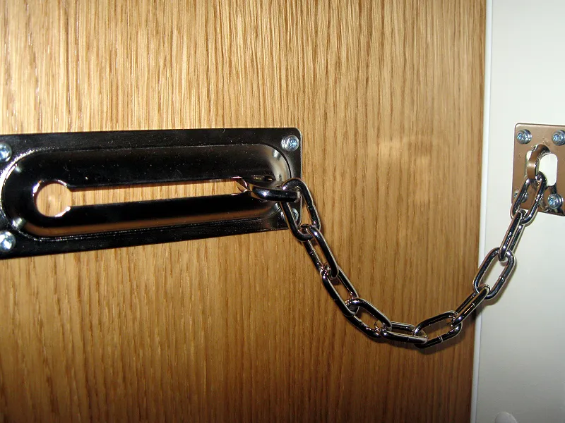 Türkette an einer Holztür als Beispiel für zusätzliche Sicherung der Tür