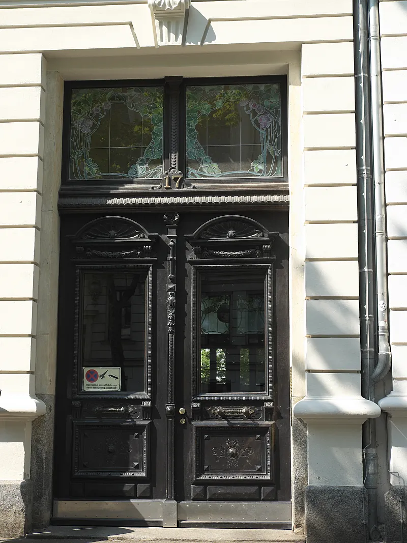 Dunkle Haustür eines Gründerzeit-Mietshauses mit Glaseinsätzen