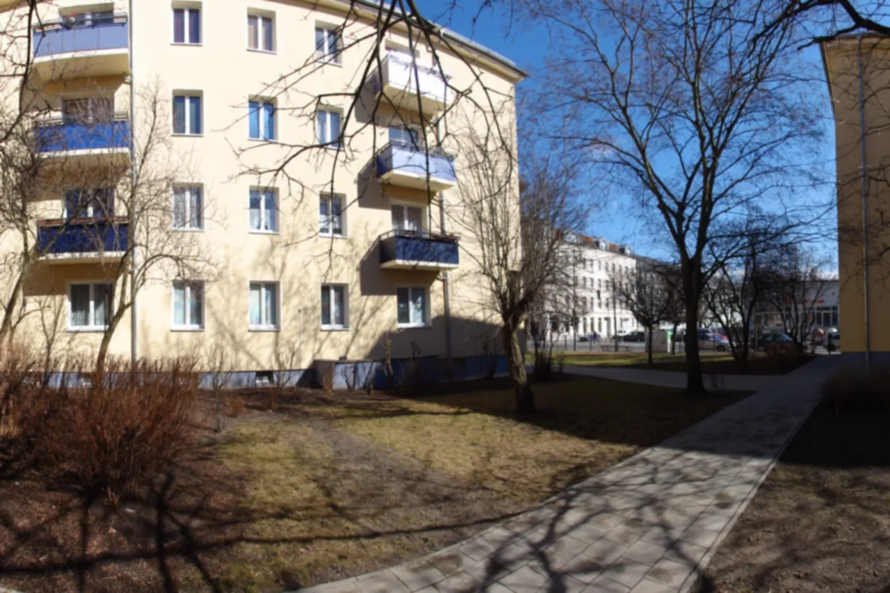 Hinterhof zwischen Altbauten mit Bäumen und Wegen in Lichtenberg